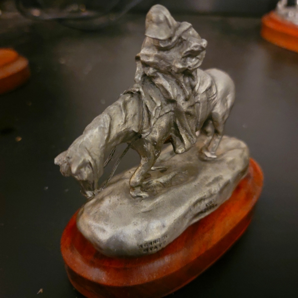 Cowboy riding horse in snow pewter sculpture by kenneth wyatt